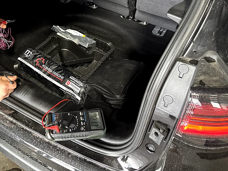Multimeter im Kofferraum bei der Fehlersuche an der Fahrzeugelektrik