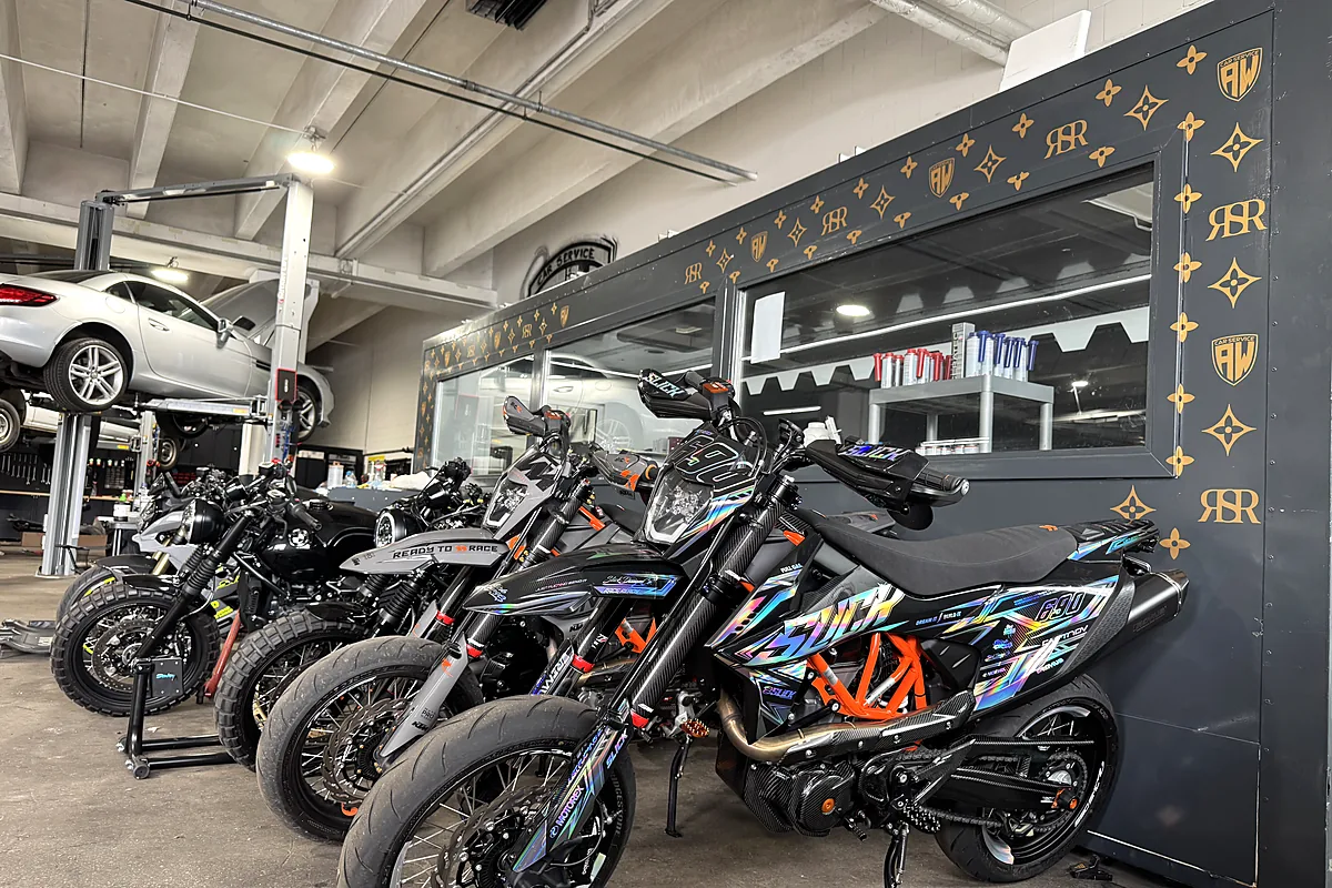 Umgebaute Motorräder vor der dunklen Glasfront der Halle in Bindlach